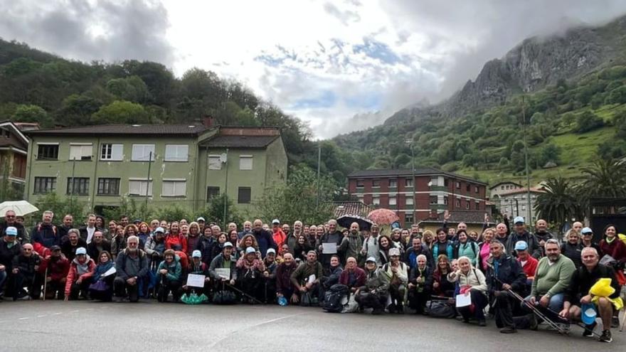 Los senderistas posan en La Foz de Morcín con el Monsacro de fondo, una vez finalizada la senda de los veinte mil pasos. | FERNANDO DELGADO