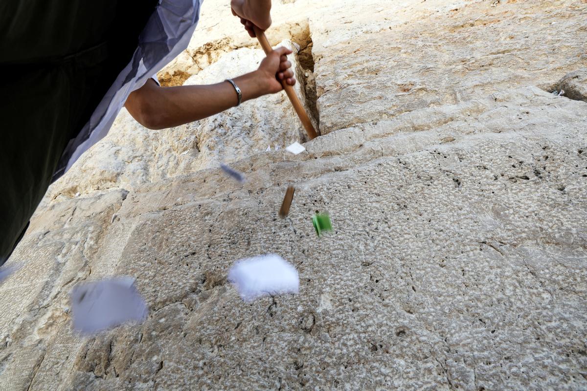 Trabajadores retiran notas de las grietas del Muro de los Lamentos para dejar espacio, como parte de los preparativos previos a la festividad judía de la Pascua, en la Ciudad Vieja de Jerusalén.