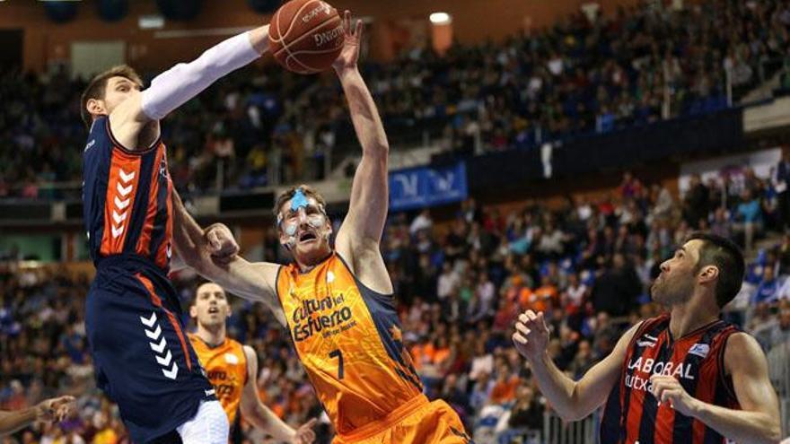 El alero italiano del Laboral Kutxa Andrés Nocioni (i), lucha el balón ante el ala-pivot estadounidense del Valencia Basket Club Justin Doellman (c) durante el partido de cuartos de final de la Copa del Rey que se disputa esta noche en el Palacio de Deportes José María Martín Carpena de Málga.