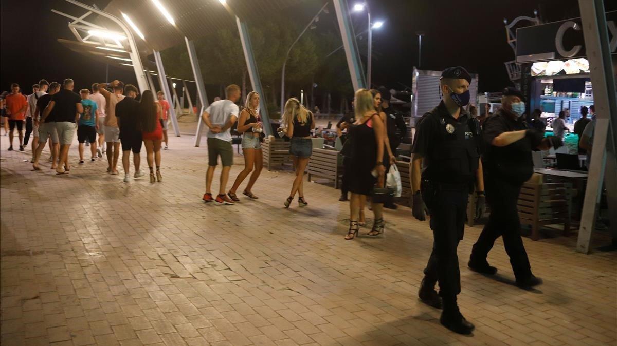 La Policía pasa delante de jóvenes sin msacarilla en Magaluf.