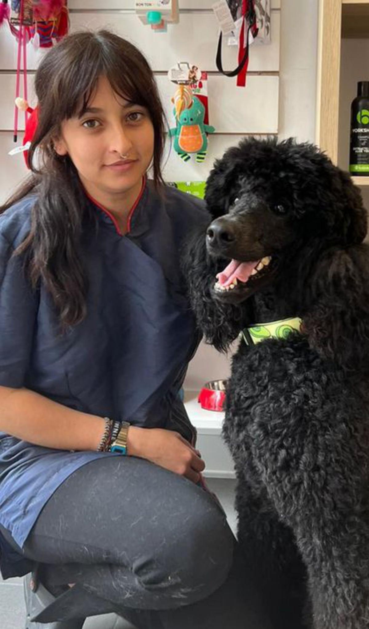 Ana Martínez-Guisasola, con un perro en su peluquería.