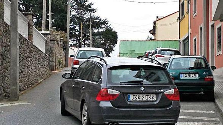 Vehículos ayer en la rúa Pombal y al fondo a la derecha un cierre que estrecha varios metros la calle.