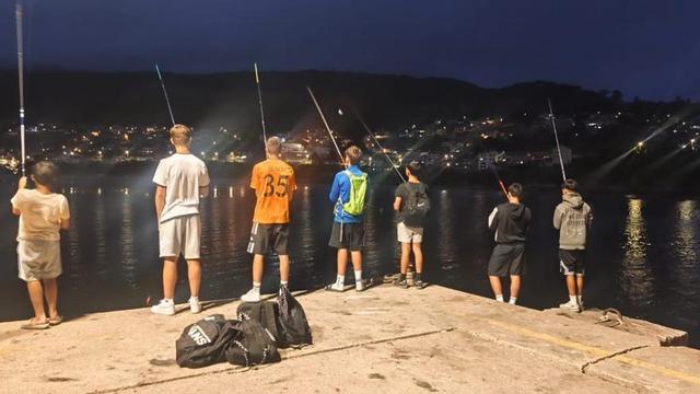 Menores pescando de noche en un espigón moañés. | FDV