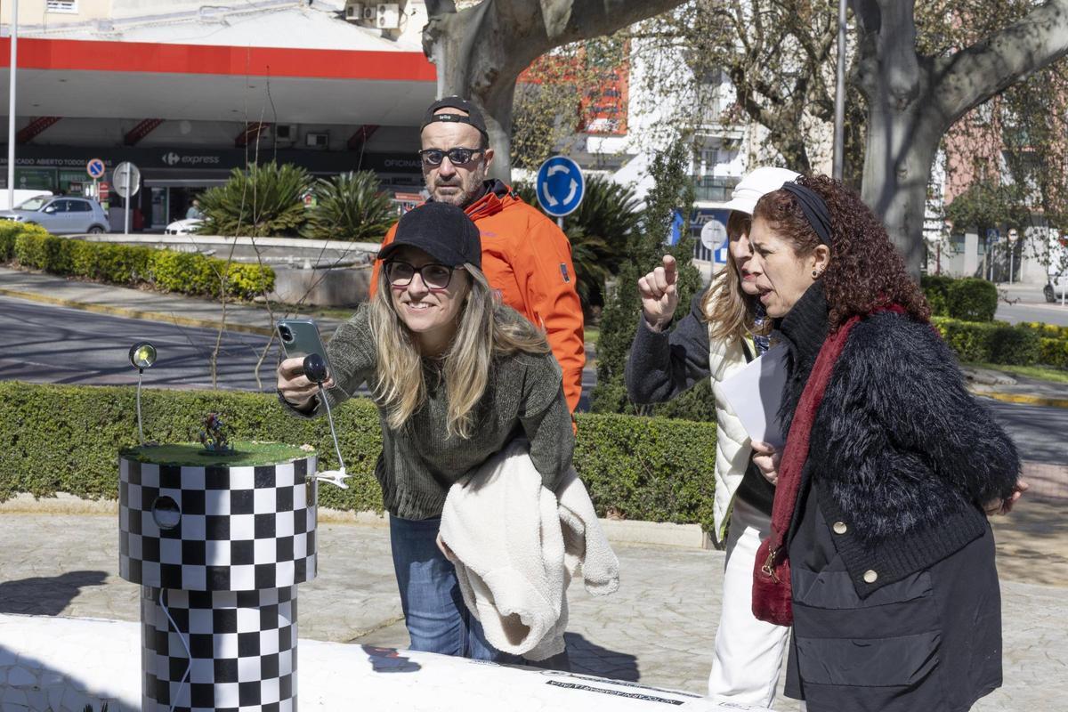 Una mujer fotografía con su teléfono móvil la falla en miniatura presentada por la comisión Passeig de Xàtiva.