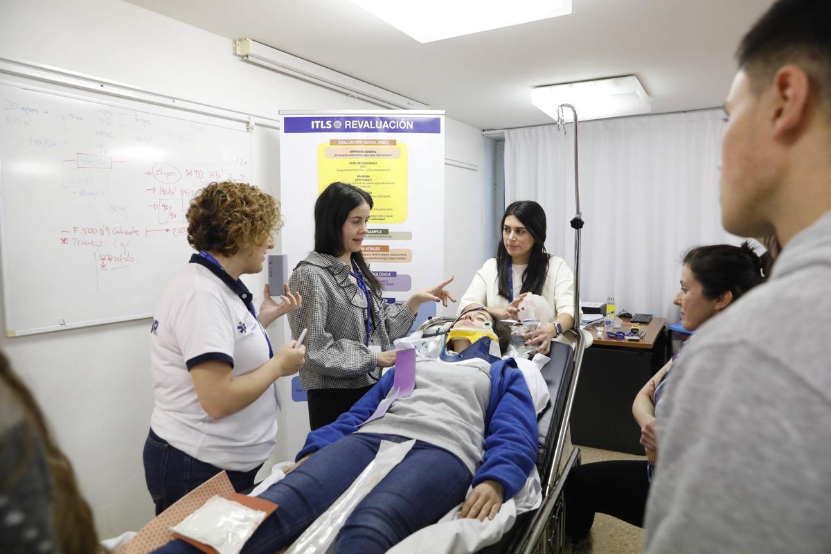 Alumnos del curso ayer, atendiendo de forma figurada a una paciente con politrauma durante un ejercicio práctico en el HUSA; a la izquierda, Mercedes Albuerne, instructora.