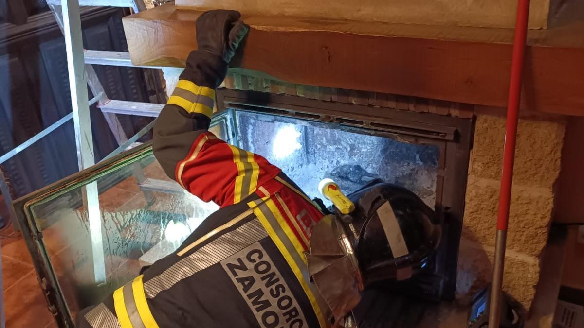 Los bomberos revisan la chimenea de una vivienda en un pueblo de Zamora.