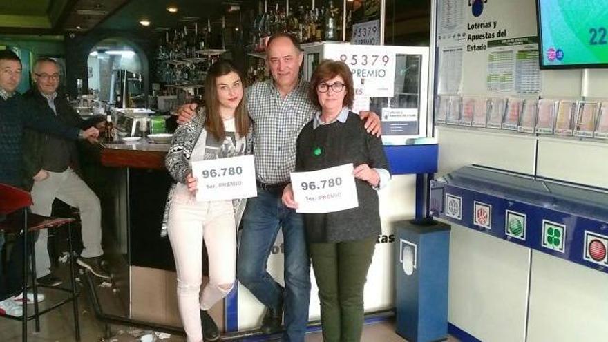 El dueño del bar Los Arcos, Carlos, y su familia, exhiben orgullosos el número premiado en el sorteo de hoy vendido en su establecimiento.