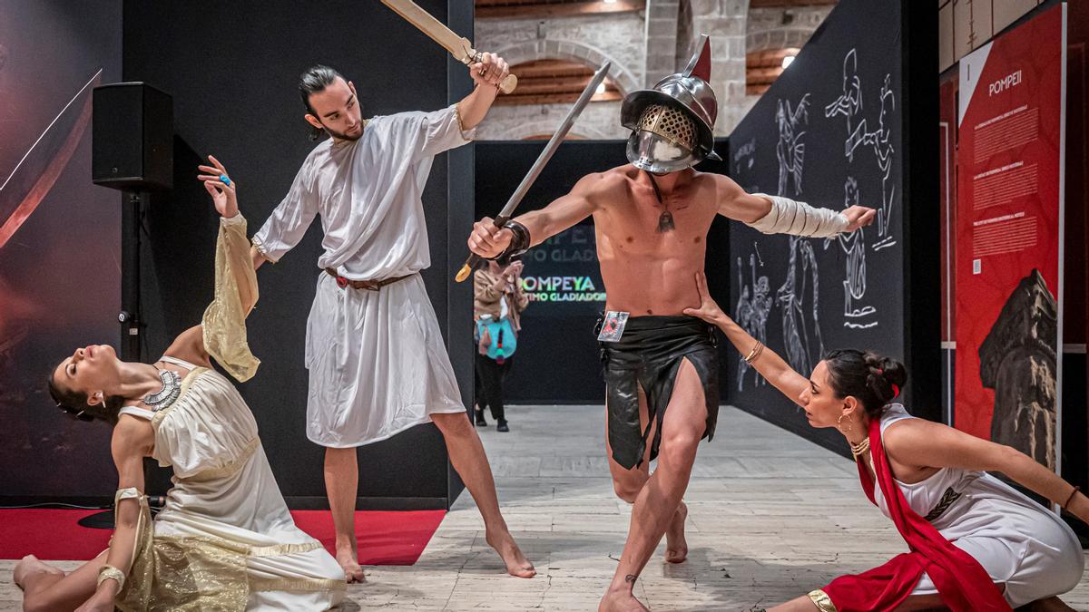 Un grupo de figurantes amenizan la presentación de la exposición.