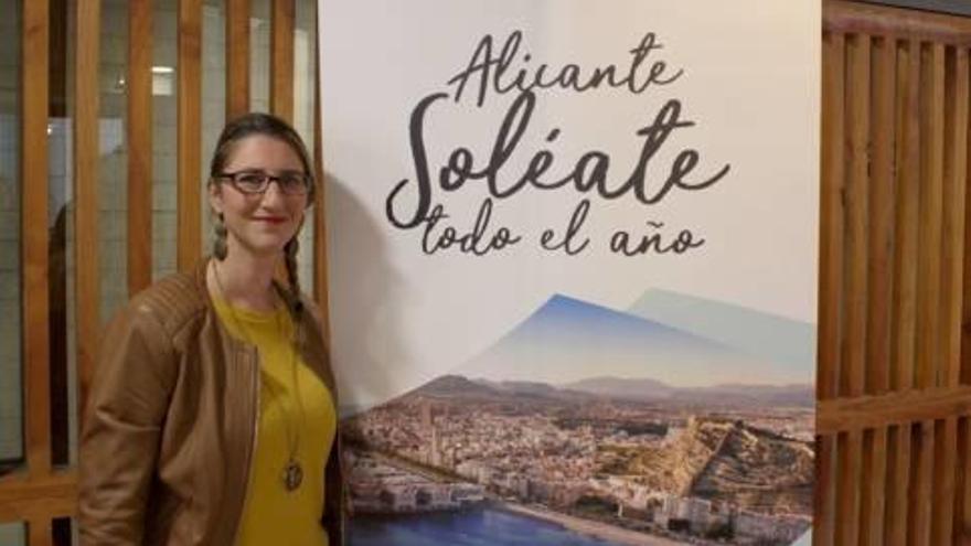 Mari Carmen de España, edil de Turismo, posa junto a una fotografía con el nuevo eslogan, ayer.