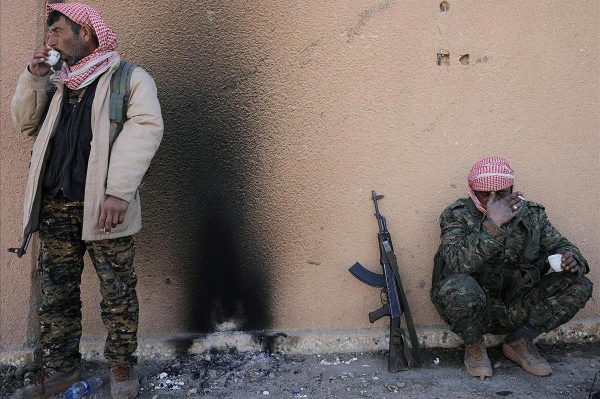 Combatientes de las Fuerzas Democráticas Sirias SDF beben té en el pueblo de Baghouz, en la provincia de Deir Al Zor, Siria