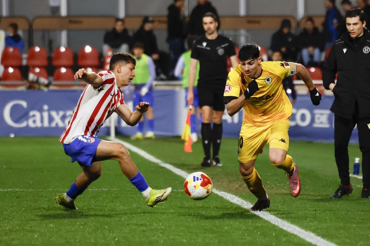 Nico Espinosa trata de superar a Belloti en carrera, durante el Atleti B-Hércules.