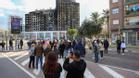 Decenas de personas contemplan el edificio quemado en Valencia.