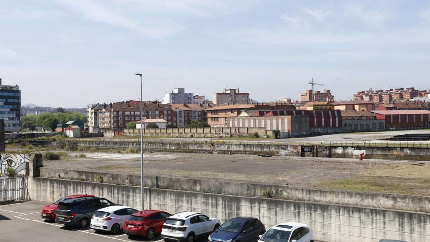 Terrenos de Naval Gijón, con una valla separando los de Pymar de los del Ayuntamiento. | ÁNGEL GONZÁLEZ