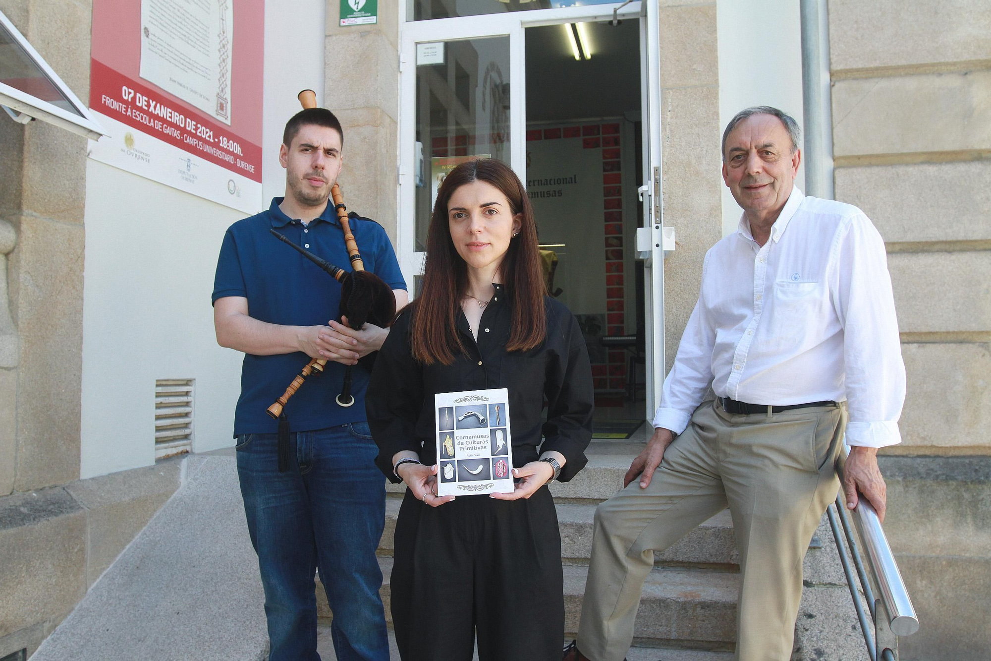 Marco, Ruth (con su libro) y Xosé Lois Foxo, en la entrada de la escuela de gaitas. // IÑAKI OSORIO