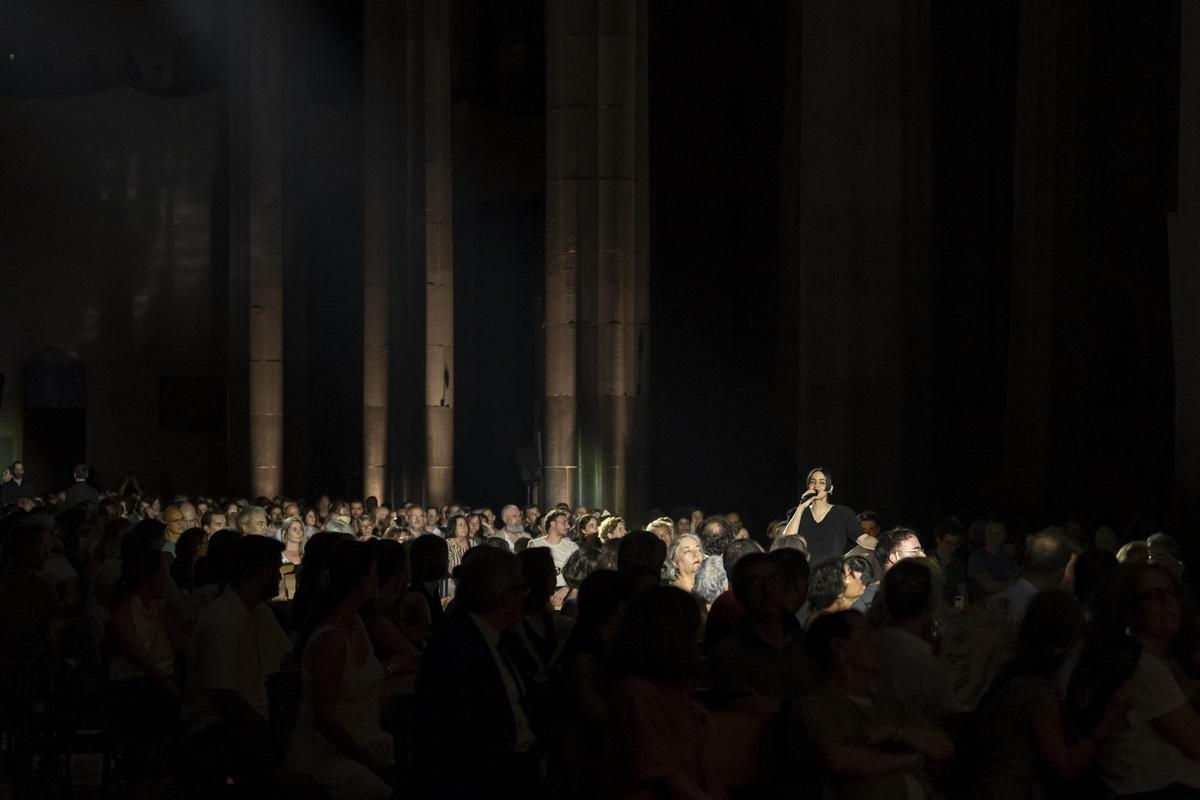 Maria Arnal canta en el pasillo de la nave central de la basílica, rodeada por el público.