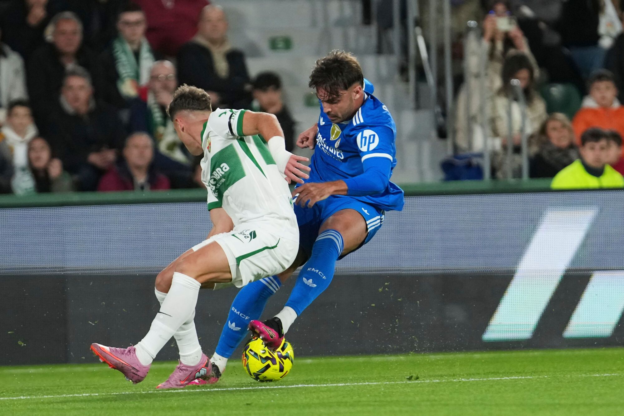 Real Madrid's Raul Asencio, right, and Elche's German Valera challenge for the ball during the Spanish La Liga soccer match between Elche and Real Madrid in Elche, Spain, Sunday, Nov. 23, 2025. (AP Photo/Alberto Saiz)
