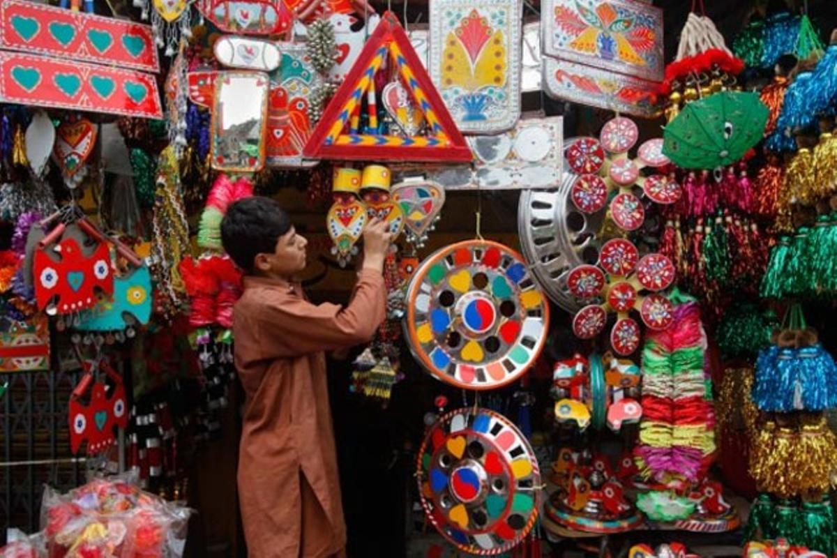 Un jove organitza la decoració de la seva botiga en un basar de Lahore, Pakistan.