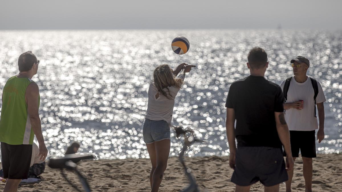 Jóvenes juegan a voley en la playa de Can Pere Antoni, en Palma.