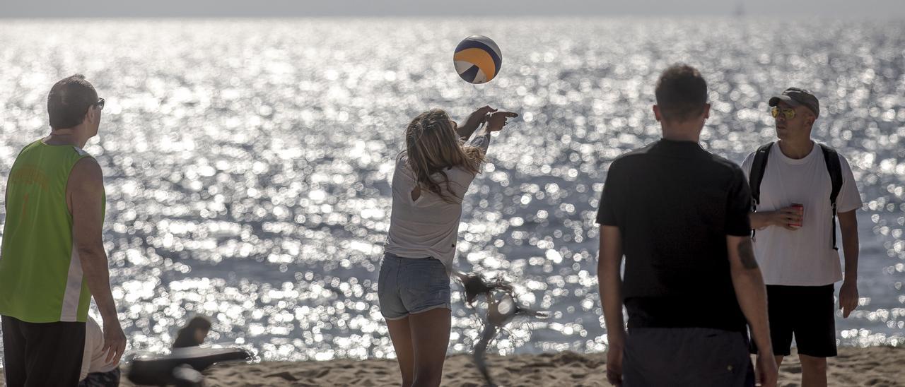 Jóvenes juegan a voley en la playa de Can Pere Antoni, en Palma.