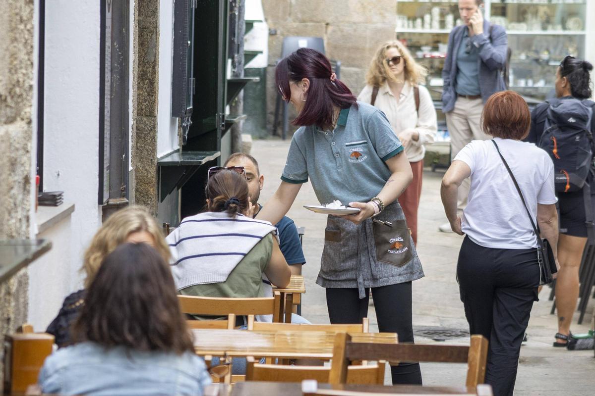Una trabajadora atiende a sus clientes en un negocio hostelero de Santiago