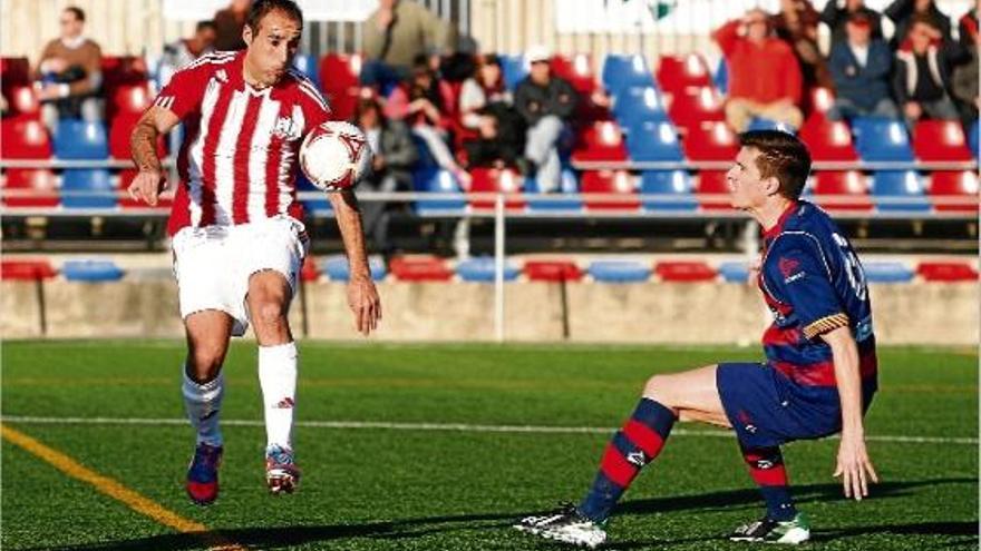 Capdevila (Huracán) condueix la pilota mentre Tito (Llagostera) intenta mantenir l&#039;equilibri durant el partit d&#039;ahir.