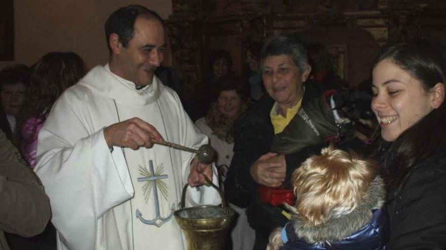 El párroco José Luis Miranda se dispone a bendecir un perro. Foto