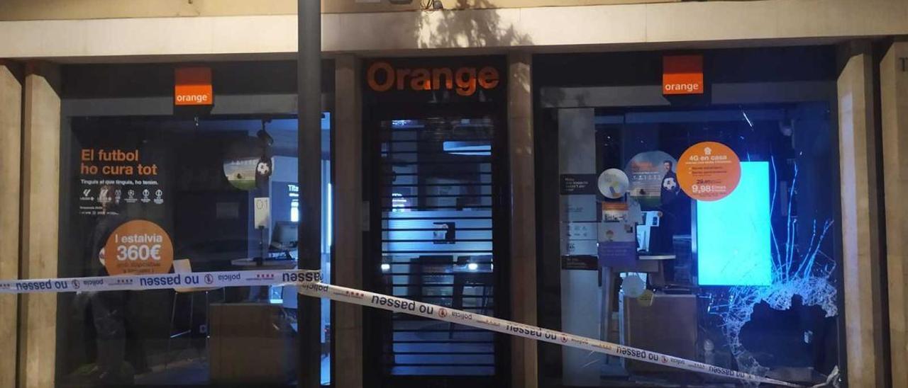 La botiga d'Orange amb un dels vidres rebentat.