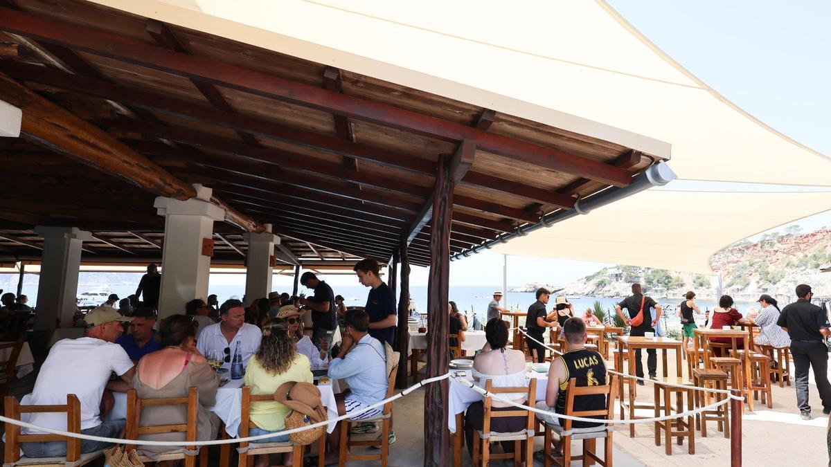 Múltiples personas disfrutan en un restaurante en Cala d'Hort.