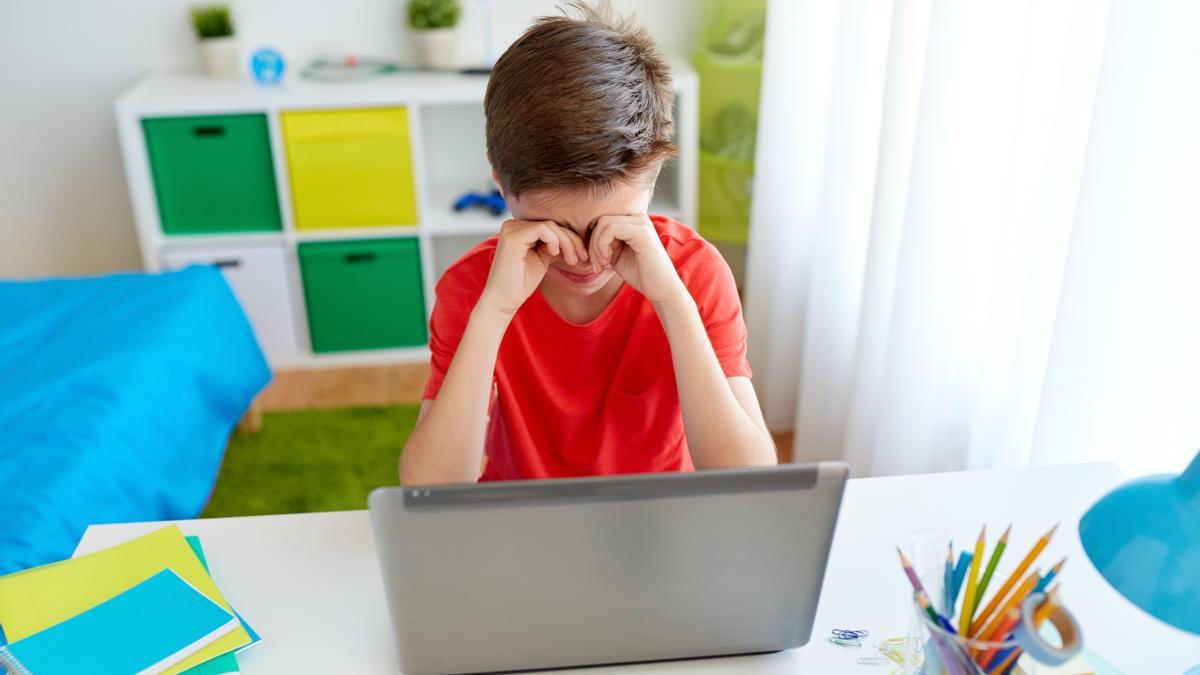 Un joven cansado ante el ordenador.