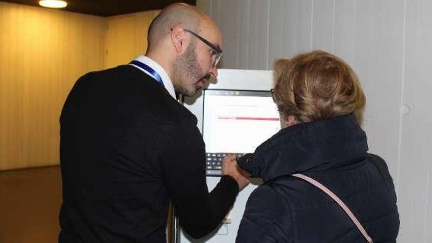 Un técnico de la empresa da instrucciones a una ciudadana.