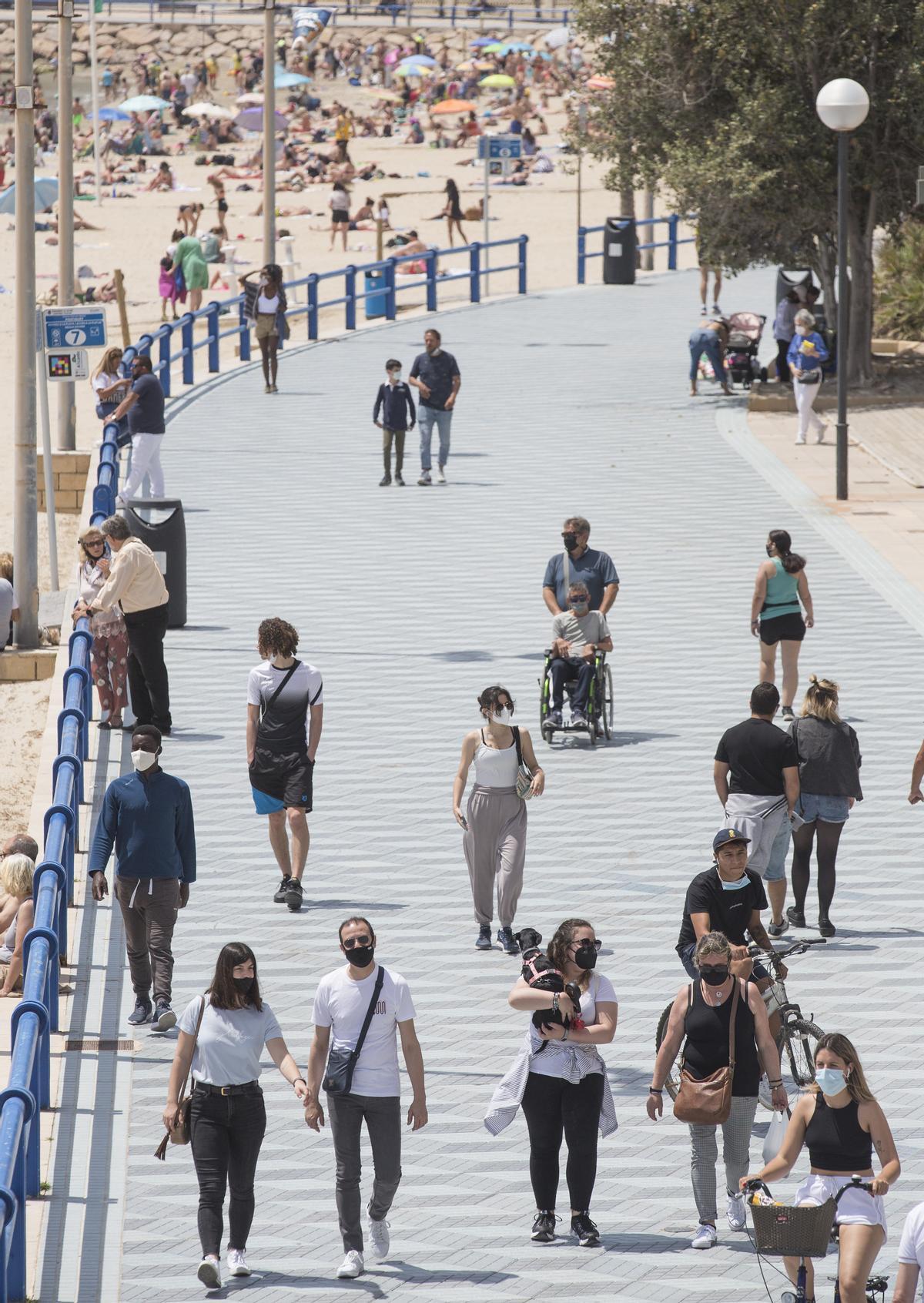 Turistas en la playa del Postiguet y el Paseo de Gómiz en Alicante