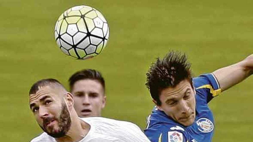 Benzema y Vergini forcejean por un balón aéreo. Foto Efe