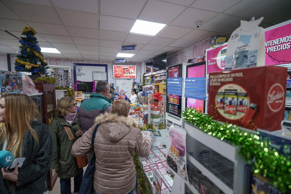 Varias personas guardando cola en el establecimiento de la plaza de los Escritores.