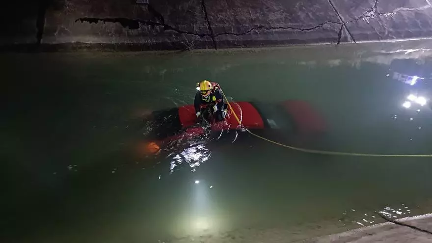 Los bomberos sacan un vehículo accidentado sumergido del canal del postrasvase, en San Miguel de Salinas