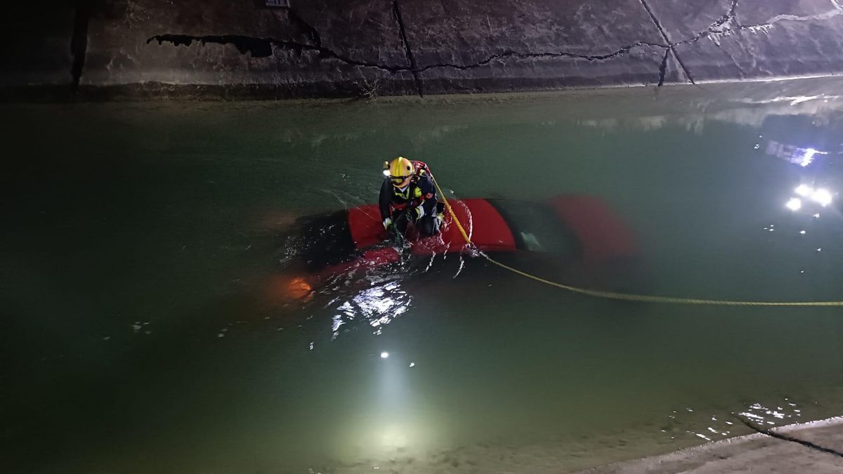 Los bomberos sacan un vehículo accidentado sumergido del canal del postrasvase, en San Miguel de Salinas