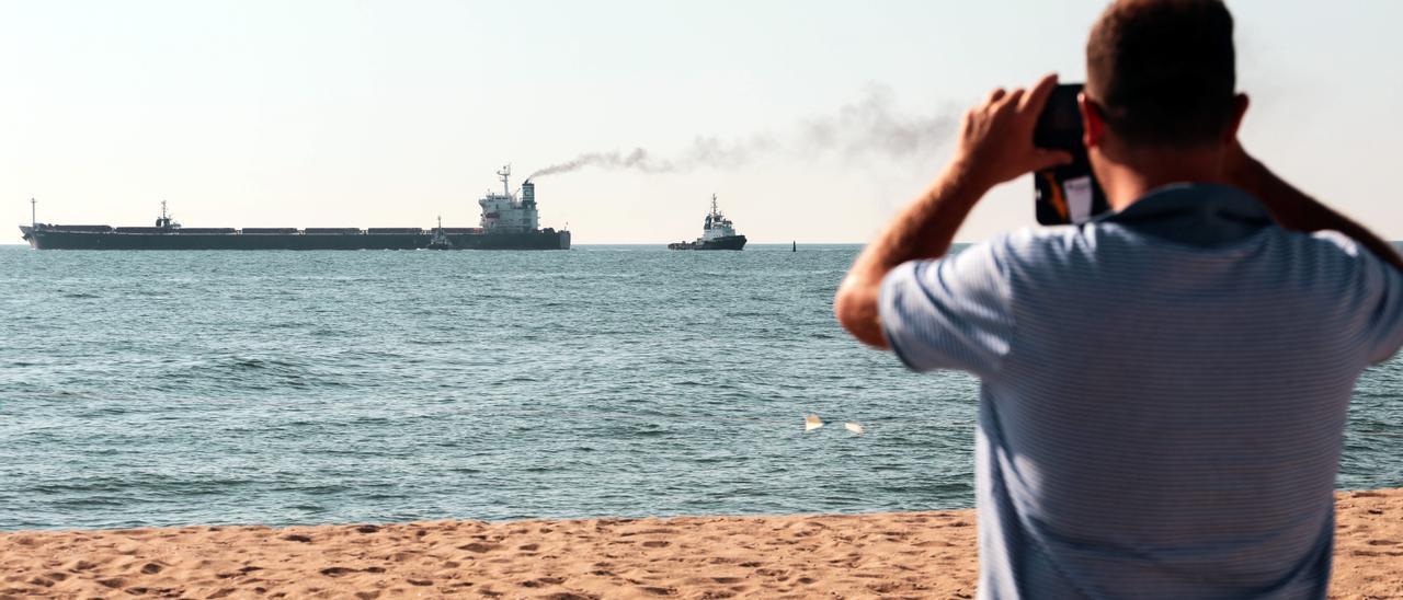 Un hombre contempla la salida un buque granelero que sale de Odessa (Ucrania) hacia China.