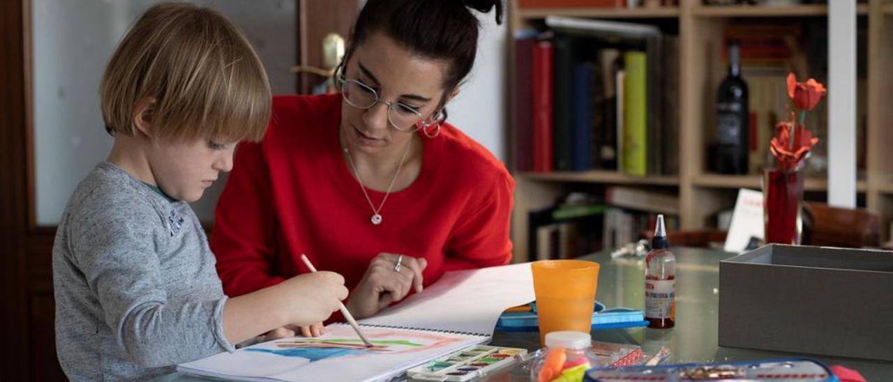 Una madre ayuda a su hijo a hacer los deberes | Efe