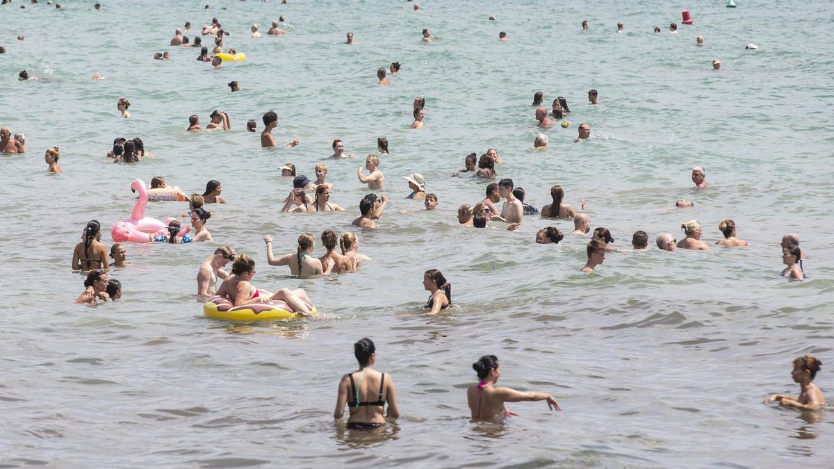 Bañistas en la playa alicantina del Postiguet, remojándose a 30 grados, como en el Caribe