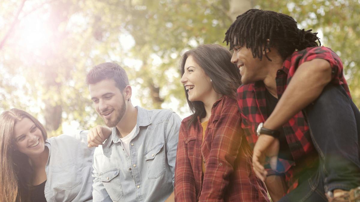 Un grupo de cuatro jóvenes riendo.