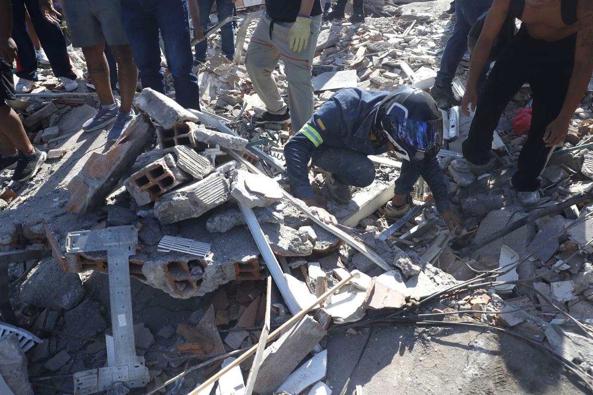 Una persona fue captada este 10 de agosto al buscar en medio de los escombros de un edificio colapsado este lunes en Cali (Colombia). Una persona fue captada este 10 de agosto al buscar en medio de los escombros de un edificio colapsado este lunes en Cali (Colombia).
