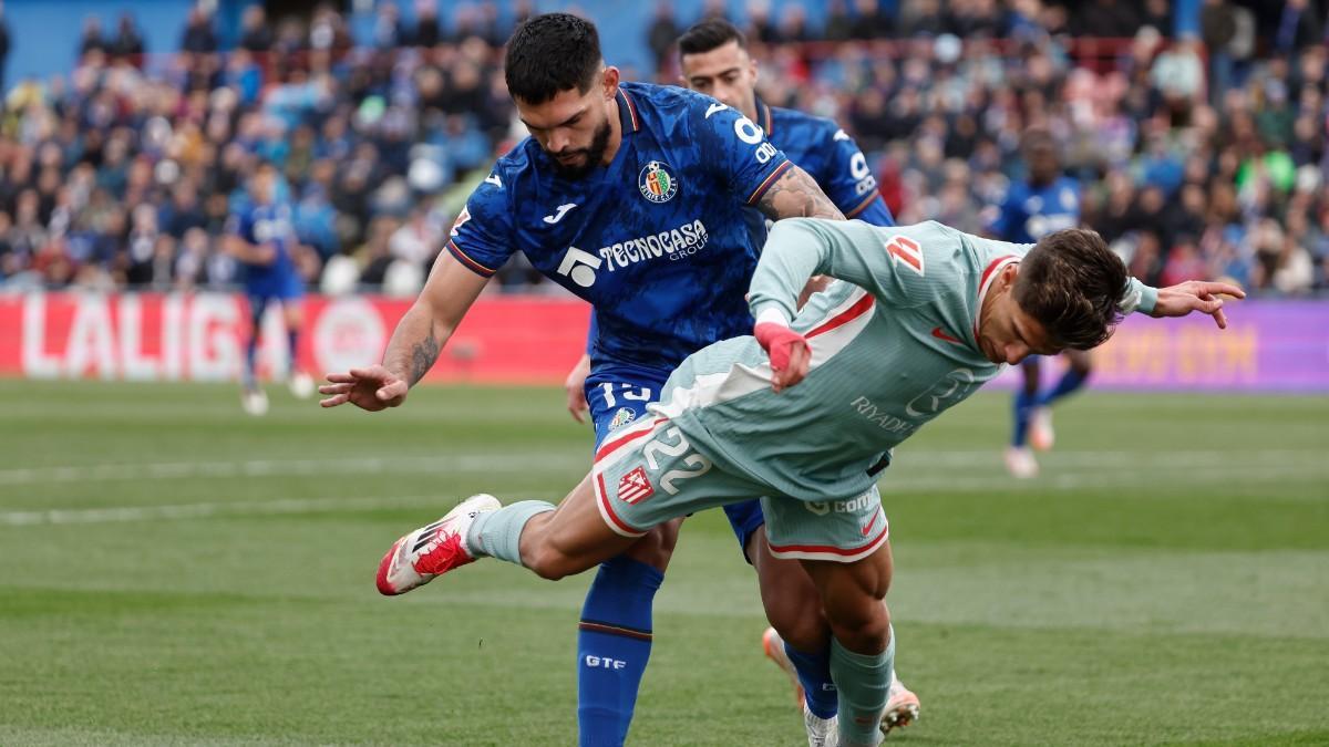 El centrocampista del Atlético de Madrid, Giuliano Simeone (d) y el defensa del Getafe Omar Alderete durante el partido de la jornada 27 de Liga que disputan este domingo en el estadio Colisum de Getafe. EFE/Sergio Peréz