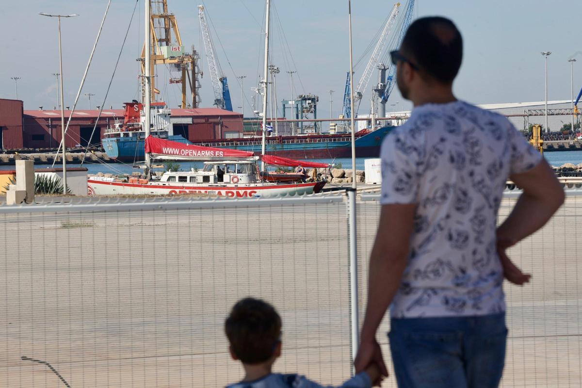 Un hombre y un niño observan el barco atracado en Sagunt.