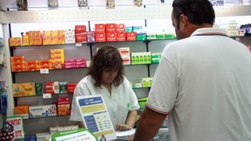 Una farmacèutica atén un usuari.