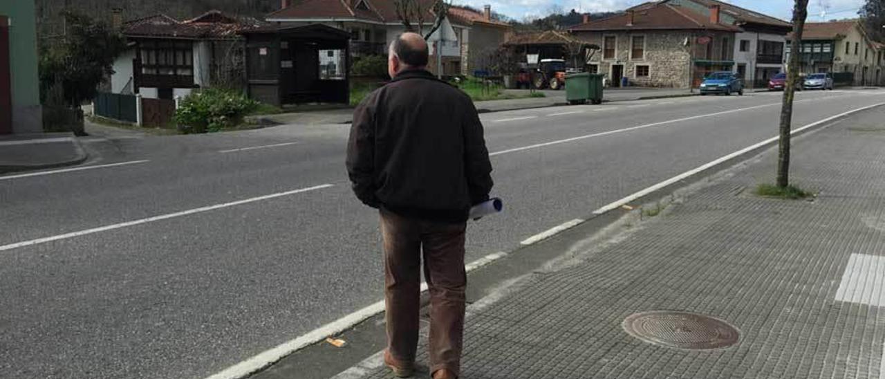 Un vecino se dispone a cruzar frente a la marquesina de Les Roces.