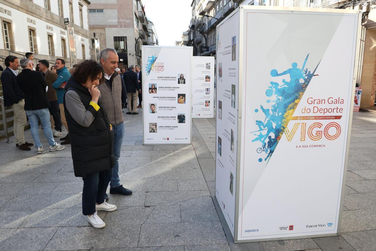 Dos personas, delante de los paneles con las candidaturas.