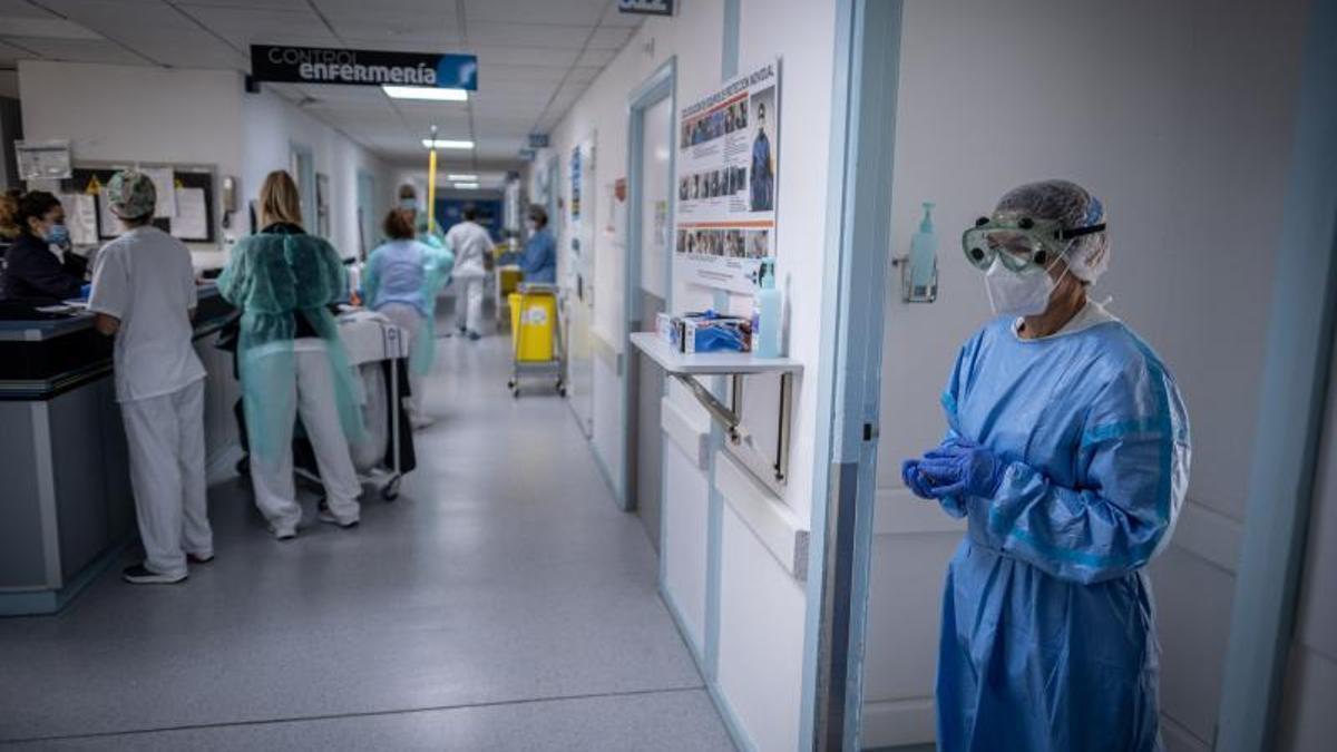 Una enfermera espera a su compañero para atender a un paciente Covid-19.