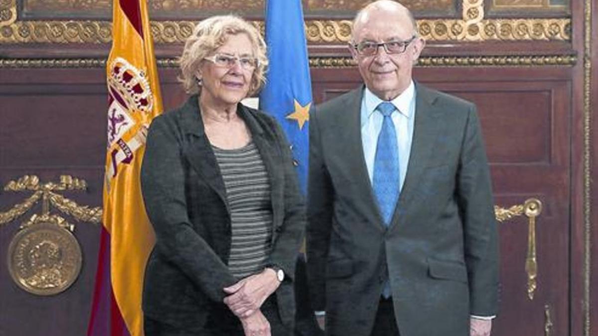 La alcaldesa de Madrid, Manuela Carmena, y el ministro de Hacienda, Cristóbal Montoro, en una reunión el pasado año.
