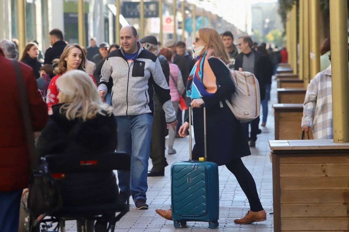 Una mujer con una maleta por la calle Cruz Conde.