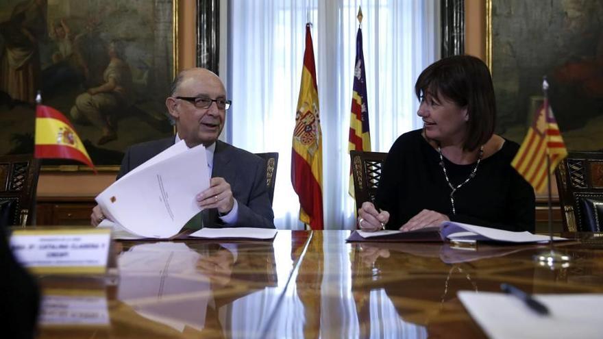 El ministro Montoro y la presidenta Armengol, ayer, firmando el acuerdo de inversiones.