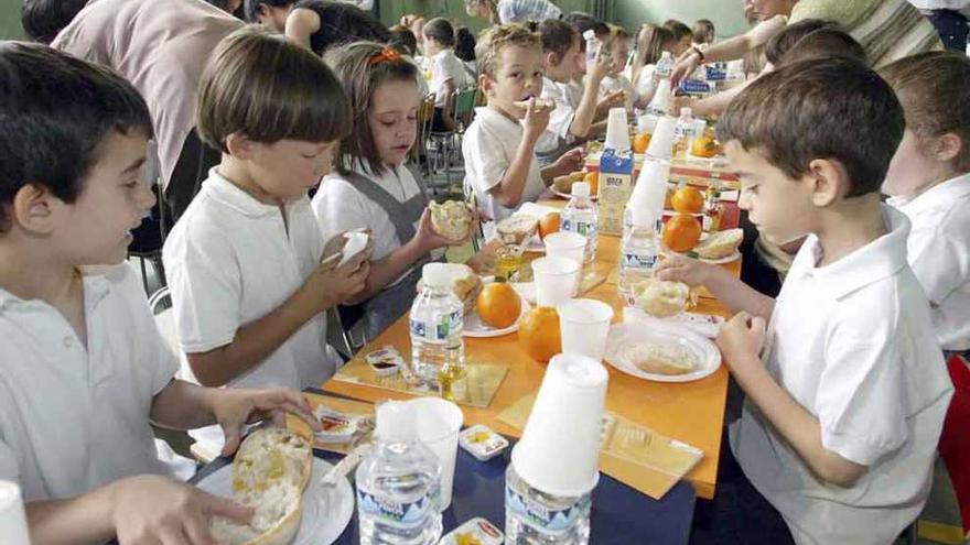 Varios niños comparten mesa durante un servicio en un comedor escolar.